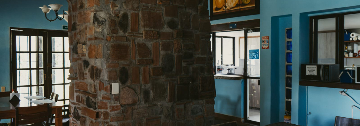 Salón campestre con pared de piedra en Sportí